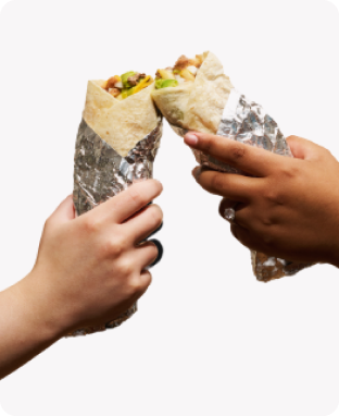 two peoples hands holding burritos